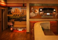 Cremefarbenes Hecksofa vor einem grossen Eight-Mile-Diner-Wandbild und einer Route-66-Kulisse