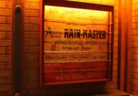 Beleuchtetes Rain-Master-Werkstattschild in einer amerikanisch gestalteten Garage