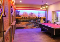 Billiardtisch vor einem farbigen Monument-Valley-Wandbild mit Strassenschildern