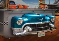 Türkisfarbene Cadillac-Front als aussergewöhnliches Möbelstück vor einer Steinwand