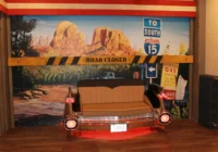 Rotes Cadillac-Hecksofa vor einem Monument-Valley-Wandbild mit Route-66-Dekoration
