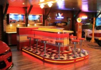 Rot beleuchtete Dinerbar mit Sitzplätzen in einer privaten Car Lounge