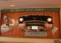 Wandgestaltung mit Eight-Mile-Diner-Schriftzug, Autofront und integriertem Bildschirm