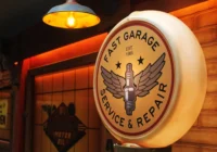 Rundes beleuchtetes Fast-Garage-Schild an einer dunkel gestalteten Wand