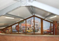 Weitläufige Oldtimerhalle mit einer Wandkulisse im amerikanischen Retro-Stil