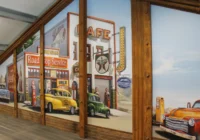 Amerikanische Road-Stop-Wandkulisse entlang einer geräumigen Oldtimerhalle