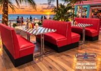 Rote American-Diner-Sitzgruppen mit Chromtischen vor einer Strandkulisse