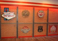 Gestaltete Backsteinwand mit Route-66-Emblem und amerikanischen Vintage-Schildern
