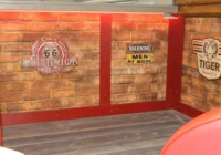 Detail einer Backsteinwand mit Route-66-Emblem und Vintage-Schildern