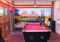 Billiardbereich mit Monument-Valley-Wandbild und beleuchteter Backsteinkulisse