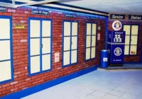 Kulissenwand in Backsteinoptik mit Werkstattfenstern, Tür und Vintage-Schildern